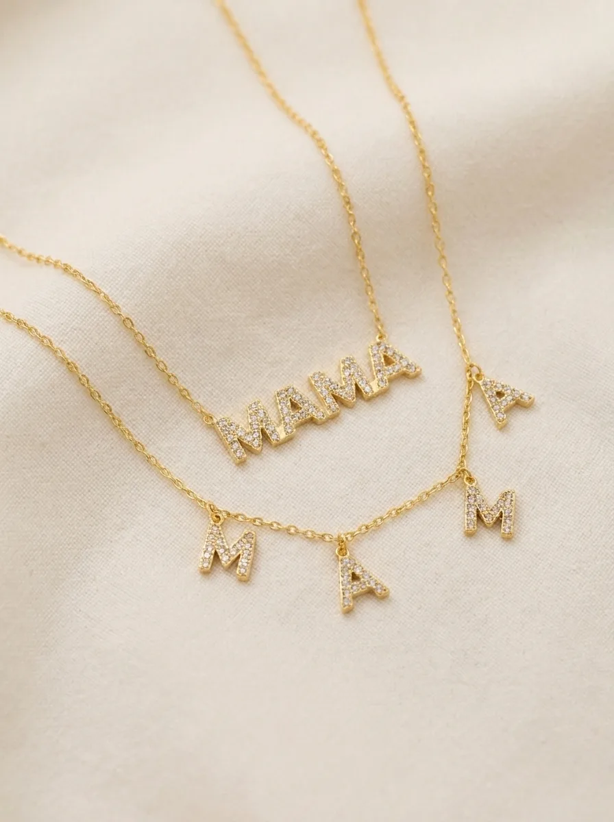 MAMA charm necklaces layered on cream linen
