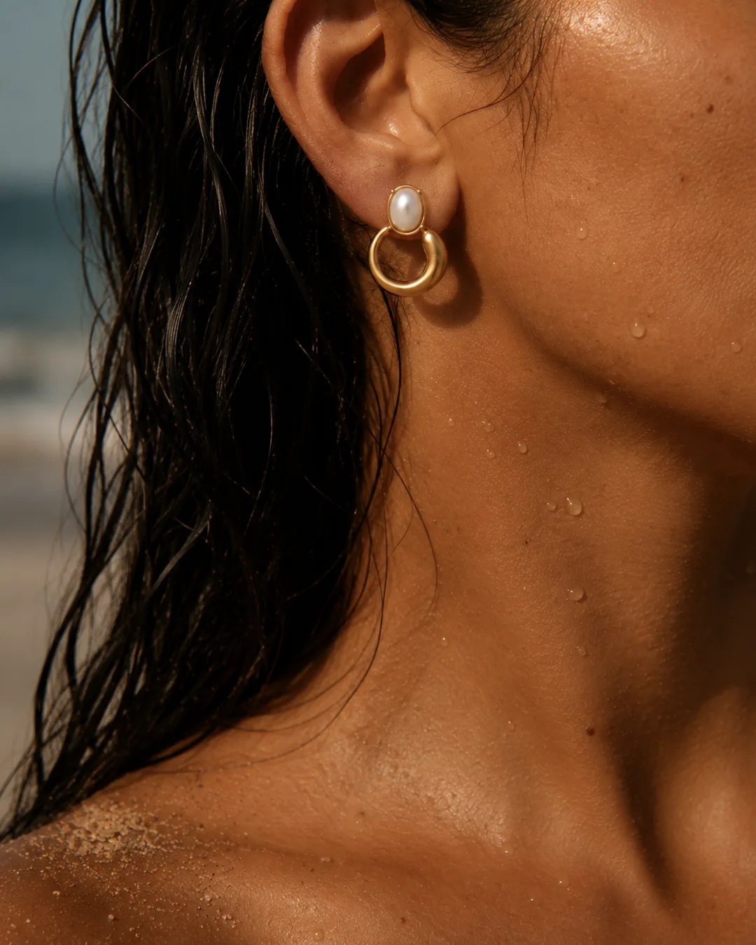 Pearl hoop earring on a model at the beach
